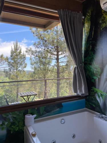a bathroom with a tub and a window with a view at Cabañas Mirador de Ézaro in Arcos