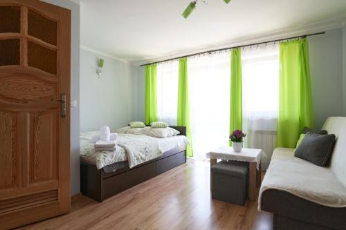 een slaapkamer met 2 bedden en een raam met groene gordijnen bij Willa u Perełki in Zakopane