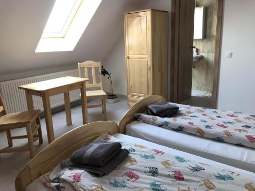 a bedroom with two beds and a table and a window at Fazekas Vendégház in Balatonkeresztúr