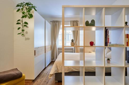 1 dormitorio con estanterías blancas y 1 cama en KARINA Lauben Lodge, en Egna