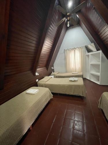 a attic room with two beds and a ceiling fan at La Martinica in Villa Carlos Paz