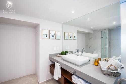 a white bathroom with a sink and a mirror at Harbor Puerto Vallarta 5009 in Puerto Vallarta