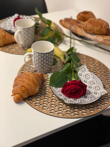 - une table avec deux assiettes de pâtisseries et des tasses à café dans l'établissement Vénus Love room Escapade romantique avec jacuzzi, à Nantes