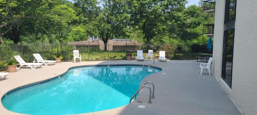 a large swimming pool with chairs and a patio at Gatlinburg Chateau Condo 309 in Gatlinburg