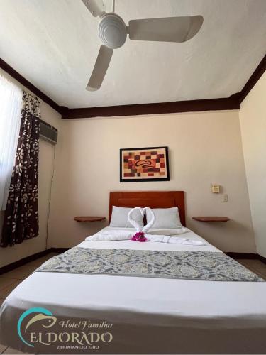 a bedroom with a bed with a flower on it at Hotel Familiar El Dorado in Zihuatanejo