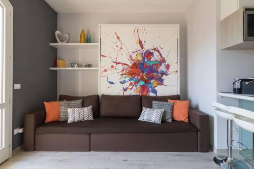 ein braunes Sofa im Wohnzimmer mit einem Gemälde in der Unterkunft Casa Francesca in Peschiera del Garda