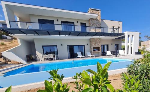 une villa avec piscine devant une maison dans l'établissement Villa Marcaléone Corse du Sud, à Cirendinu
