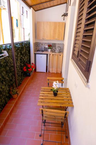 a balcony with a wooden table and a kitchen at Sicily in Love - Rooms & Breakfast in Taormina