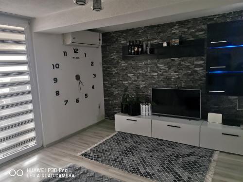 a living room with a large clock on the wall at Center Struga Apartment in Struga