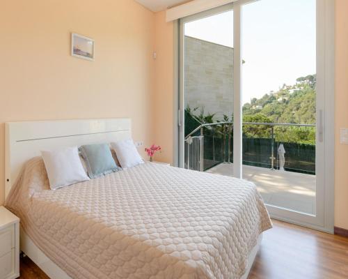 1 dormitorio con cama y ventana grande en Danlux fiona, en Tossa de Mar