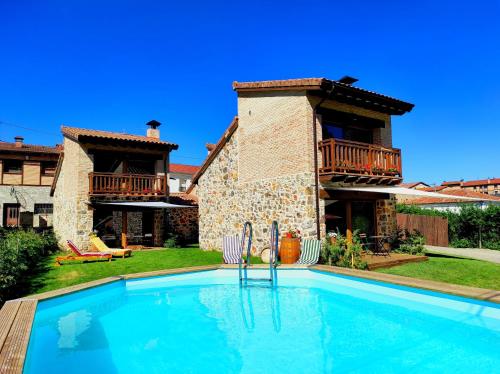 une villa avec une piscine en face d'une maison dans l'établissement La Galiana loft nature, à Casarejos