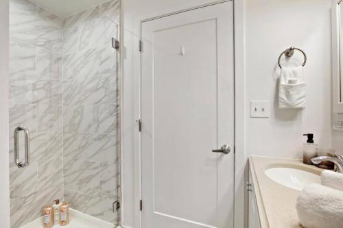 a white bathroom with a shower and a sink at 1BR Peaceful & Complete Apt with In-unit Laundry - Lake 303 in Chicago