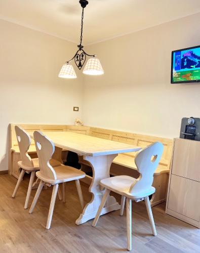 a kitchen with a table and four chairs at EMARGHE, CASA A MOENA in Moena