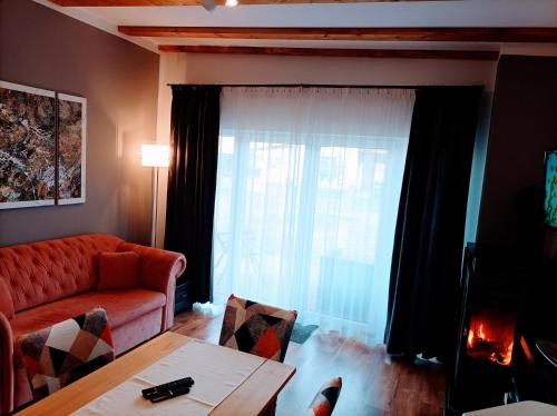 sala de estar con sofá rojo y ventana en Jasień 77 B, en Czarna Dąbrówka