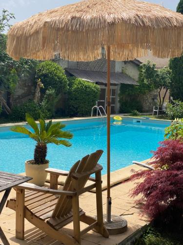 a chair and an umbrella next to a swimming pool at Lou Mut in Lectoure