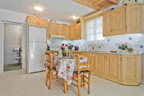una cocina con armarios de madera y una mesa con sillas. en Mountain & Sea Villa, en Kyra Panagia