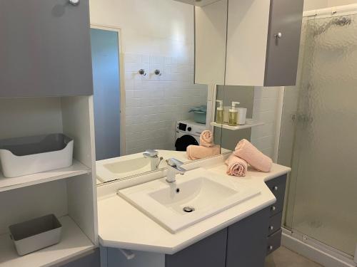 a white bathroom with a sink and a mirror at Appartement spacieux et lumineux Calanques Sormiou in Marseille
