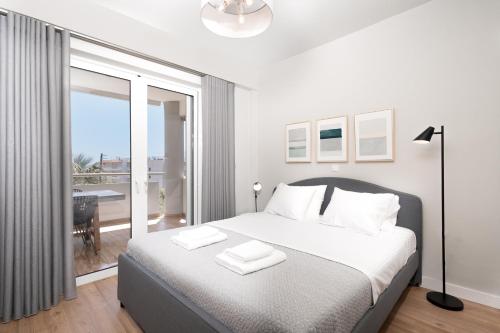 1 dormitorio con 1 cama grande y balcón en Blue Avra Apartment by A&D Properties, en Porto Rafti