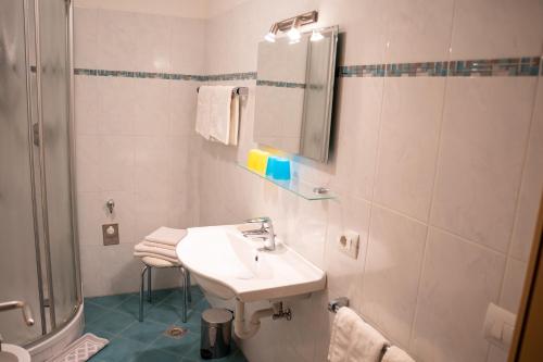 a white bathroom with a sink and a shower at Wiesgut in Vollan