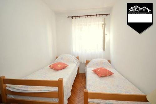 two beds in a small room with a window at Apartment Jelka in Herceg-Novi
