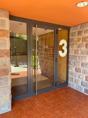 a glass door with the number three on a brick building at Apartamento Bárcenas 3 in Llanes