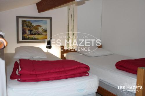 - une chambre avec 2 lits et des couvertures rouges dans l'établissement Mazet l’Olivier, à Saint-Martin-de-Brômes