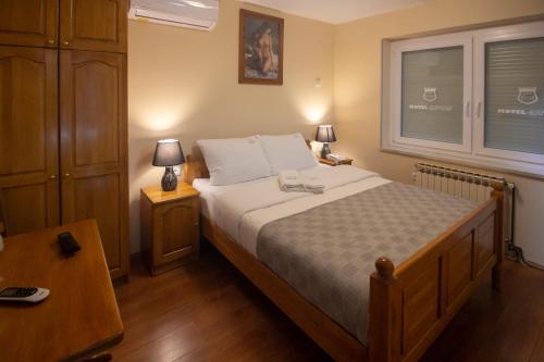 a bedroom with a bed and two lamps and a window at Motel Atos in Laktaši