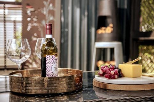 マタマタにあるHOH - Hazel's Boudoirのワイングラス付きのテーブルに座ったワイン1本