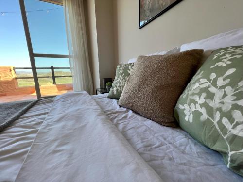a bedroom with a bed with pillows and a window at Magnificent apartment Mar'y'Golf with SPECTACULAR VIEW! High-speed internet, Remote Work in Mojácar