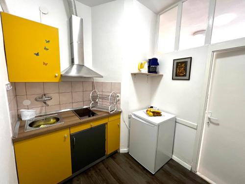 a small kitchen with yellow cabinets and a sink at Apartment Marija in Vodnjan