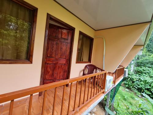 a house with a wooden door and a balcony at Ceiba lodge in Drake