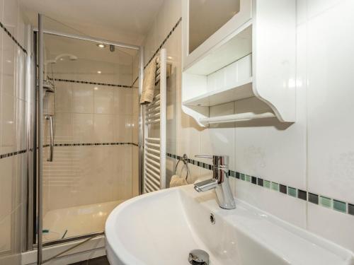 a white bathroom with a sink and a shower at Carn Cottage in Long Preston