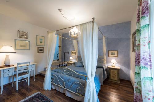 1 dormitorio con cama con dosel y escritorio en Gente Vibia bed and breakfast, en Monte Castello di Vibio