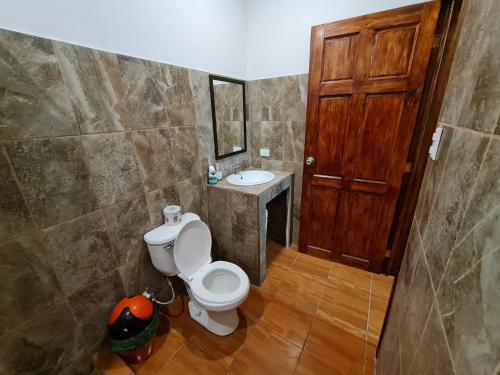 a bathroom with a toilet and a sink at Ceiba lodge in Drake