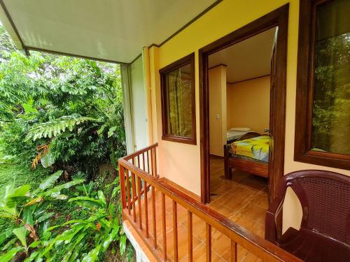 a balcony of a house with a bedroom in the background at Ceiba lodge in Drake