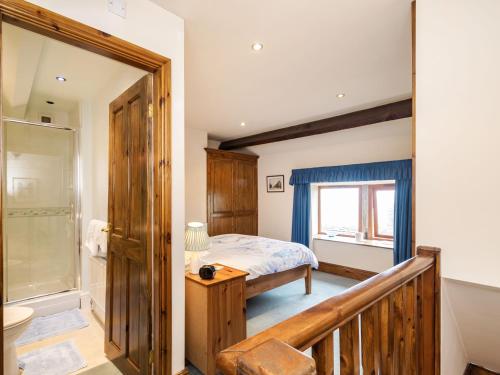 Un dormitorio con una cama y una ducha a ras de suelo. en Green Clough Farm, en Bradford