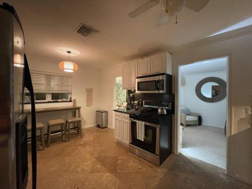 a kitchen with a stove top oven in a room at Hot tub, tiki bar, outdoor shower, near Intercoastal Waterway! in West Palm Beach