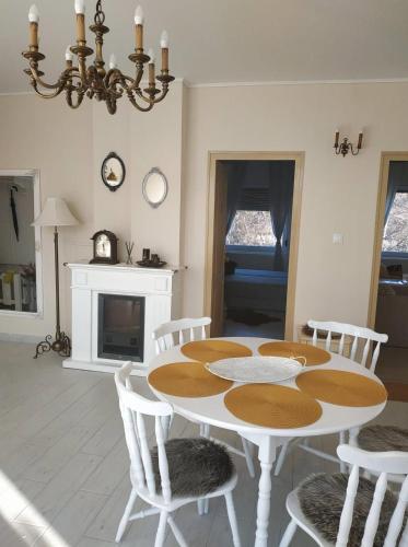 a white dining room with a table and chairs at Wagner Apartman Tata in Tata