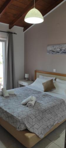 um quarto com uma cama grande e lençóis brancos em Villa Skabus - Apartment em Liapades