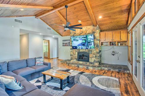 a living room with a couch and a stone fireplace at Waterfront Yantis Retreat with Deck and Zipline! in Yantis