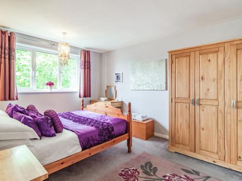 オールドバラにあるCowmans Cottageのベッドルーム1室(ベッド1台付)、木製キャビネットが備わります。
