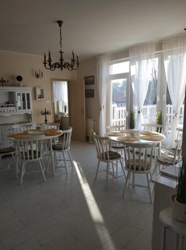 a dining room with tables and chairs and a kitchen at Wagner Apartman Tata in Tata