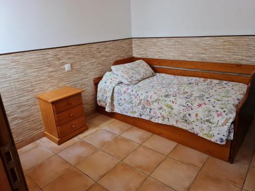 um pequeno quarto com uma cama e uma mesa de cabeceira em Casa ERIZO em Caleta de Sebo
