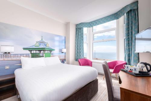 um quarto de hotel com uma cama, uma secretária e uma janela em Best Western Carlton Hotel em Blackpool