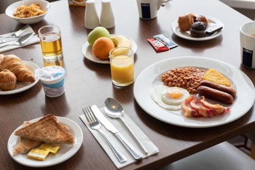 a wooden table with plates of breakfast food on it at Best Western Carlton Hotel in Blackpool