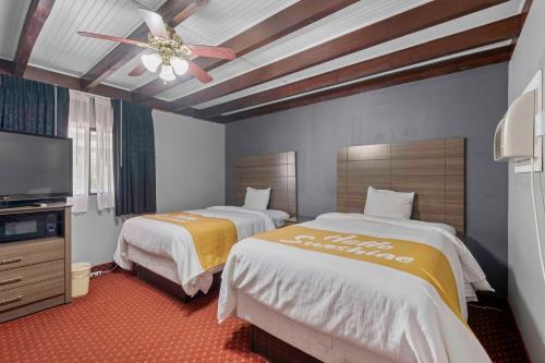 a hotel room with two beds and a ceiling fan at Budget Lodge in Ruidoso