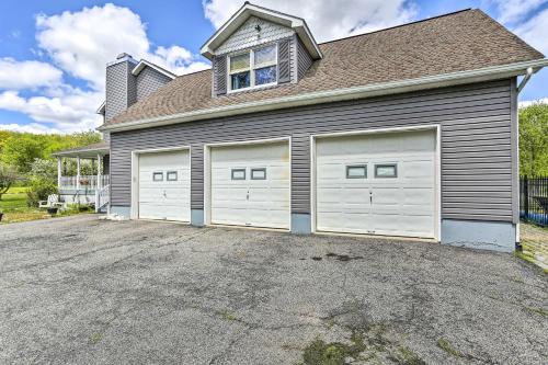 a house with two garage doors in a driveway at Pet-Friendly Pond View Loft with Private Pool! in Walden