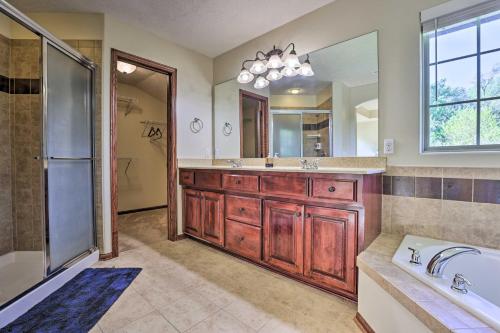 a bathroom with a tub and a sink and a mirror at Spacious Omaha Home with Expansive Yard and Patio in Omaha