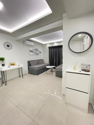 een woonkamer met een bank en een spiegel bij Princess Luxury Suite in Paralia Katerinis