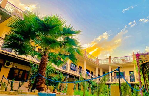 a palm tree in front of a building at Hotel Restaurant La Kasbah in Tinerhir
